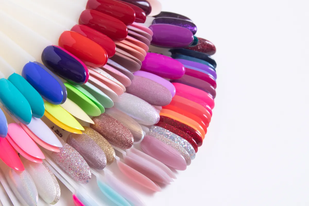 Ein Fächer aus Nageltips mit einer Regenbogenpalette aus Gel-Lack-Farben