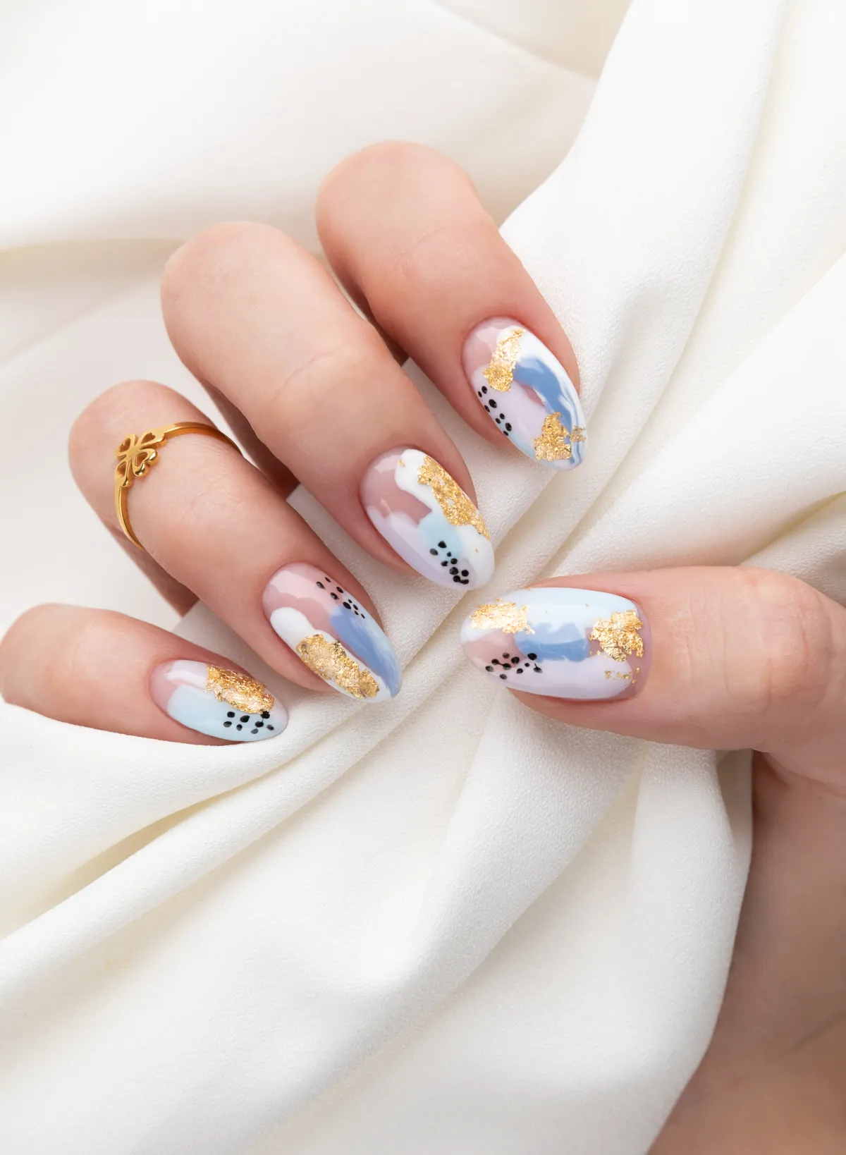 Mandelnägel mit pastelliger, abstrakter Nail Art und Blattgold auf weißer Seide