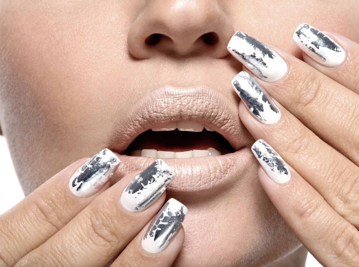 Nägel mit spiegelndem Silber-Chrome-Finish nah an den Lippen