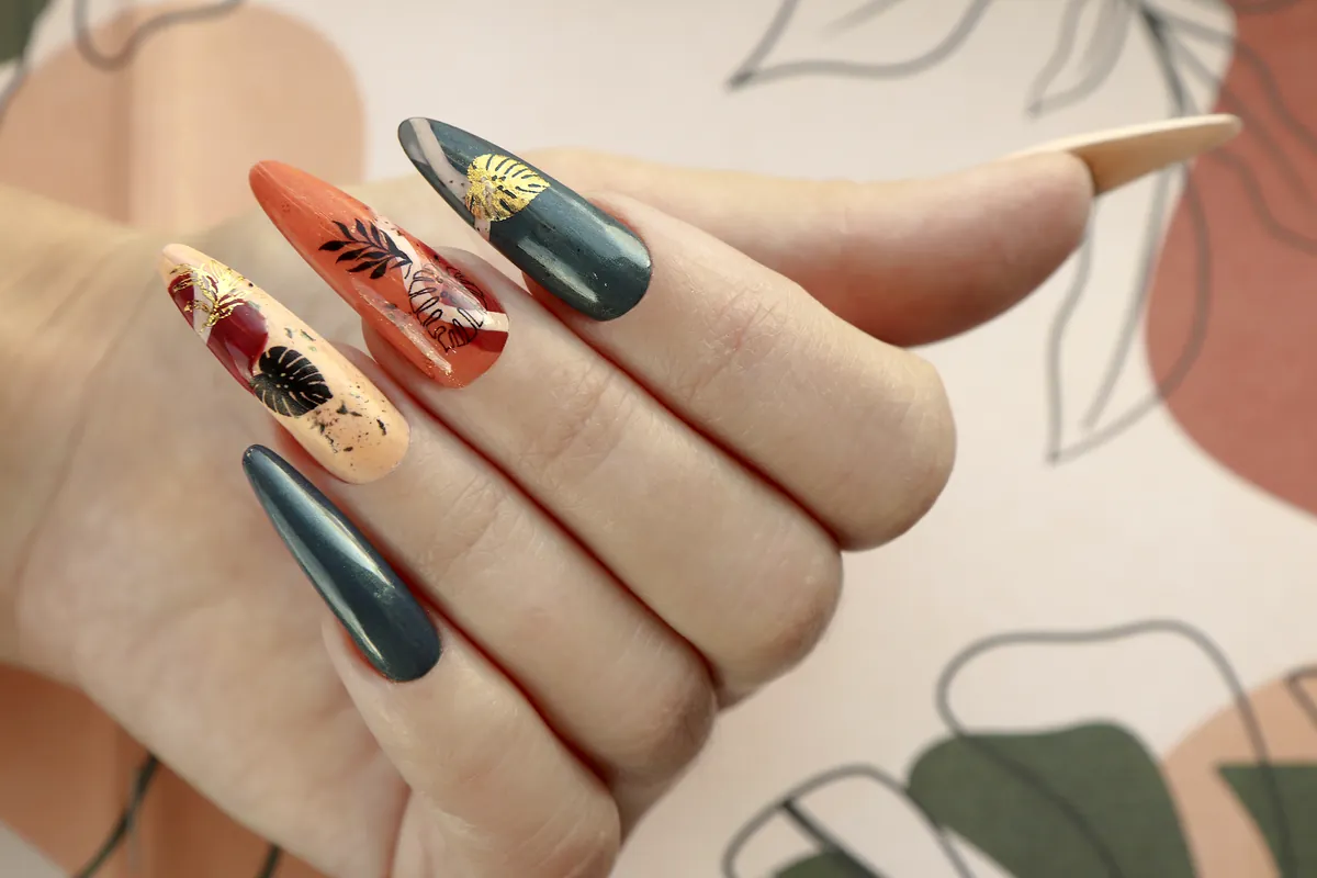 Lange Mandelnägel in tiefem Grün und gebranntem Orange mit Blattmotiven